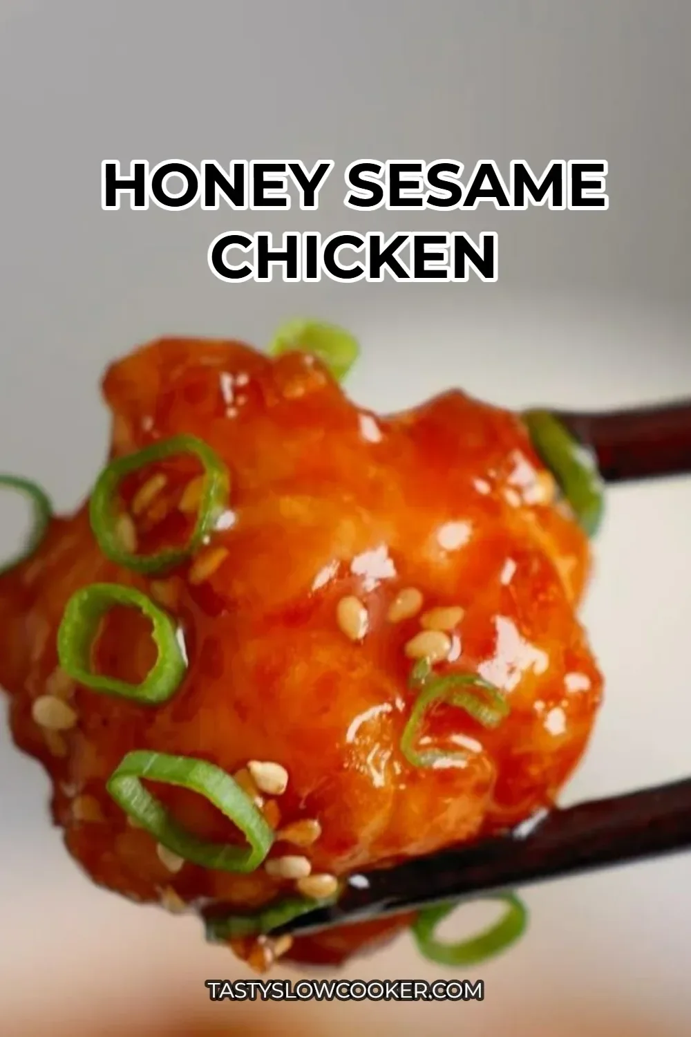 Plate of Honey Sesame Chicken garnished with sesame seeds and green onions.