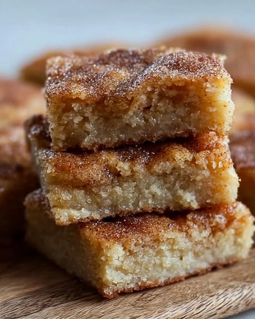 Delicious homemade Cinnamon Sugar Blondies on a plate with a sprinkle of cinnamon sugar