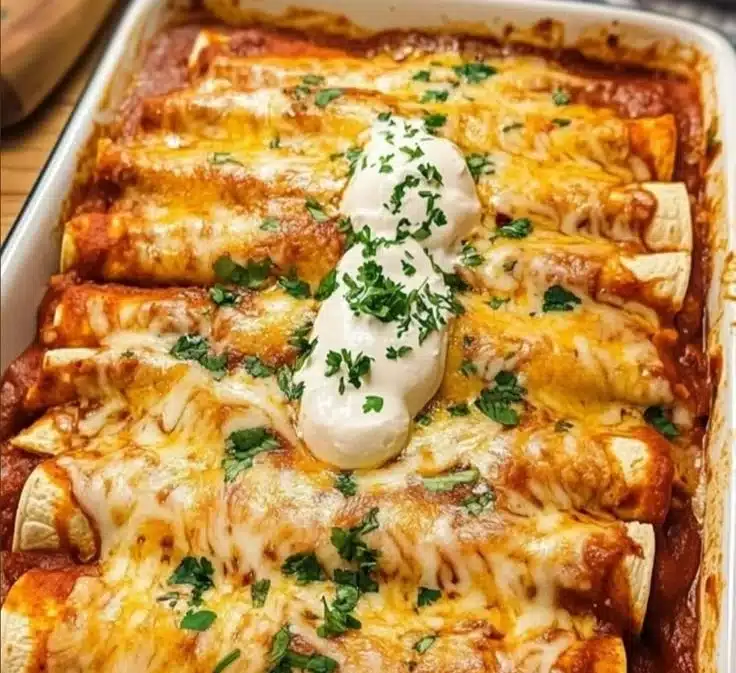 Easy chicken enchiladas topped with cheese and served on a plate.