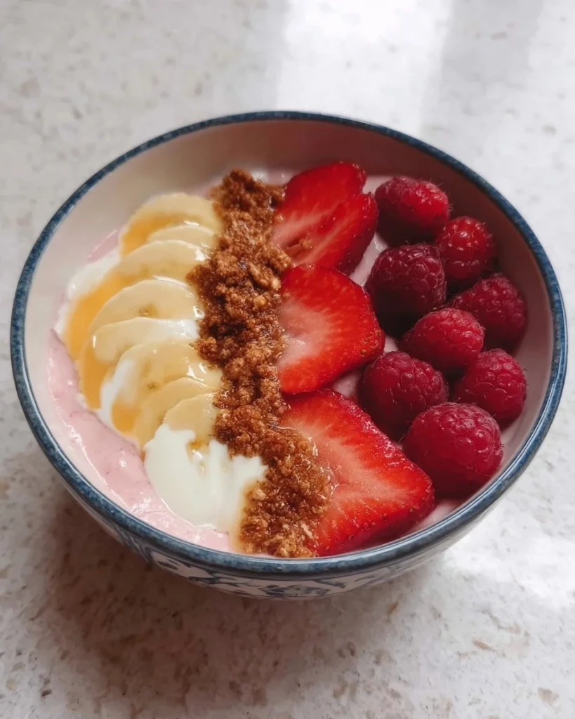 Colorful fruit smoothie bowl topped with Greek yogurt and fresh fruits
