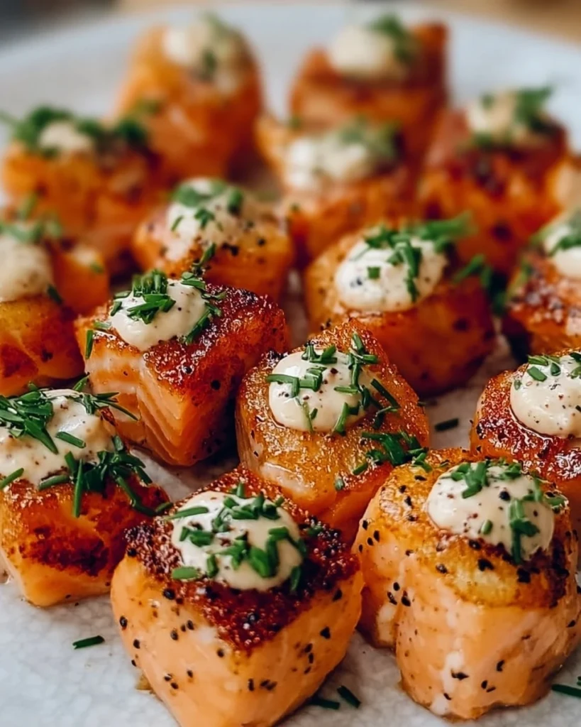 Delicious Bang Bang Salmon Bites served on a plate, garnished with sesame seeds.