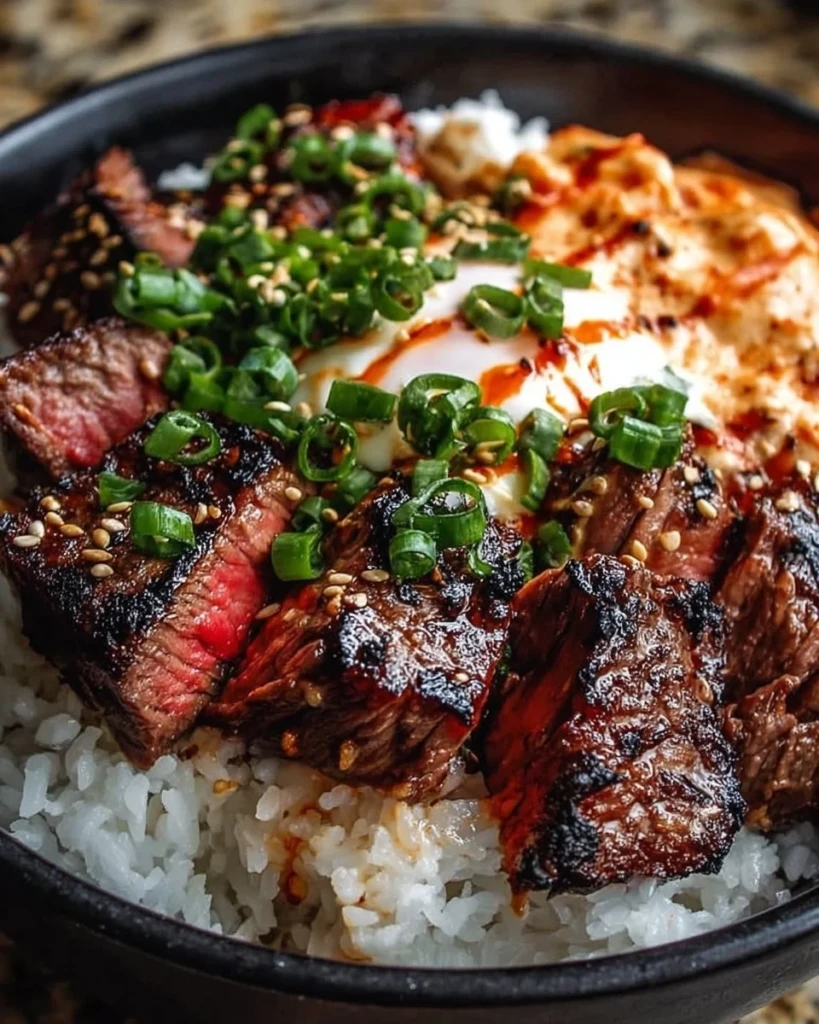 Korean BBQ steak rice bowls topped with fresh vegetables and sauce
