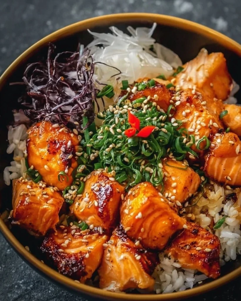 Crispy salmon and rice bowl topped with fresh vegetables.