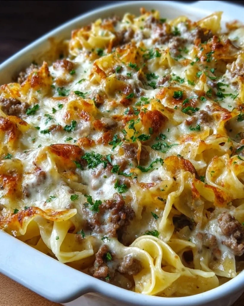 Sour cream beef noodle casserole dish garnished with herbs