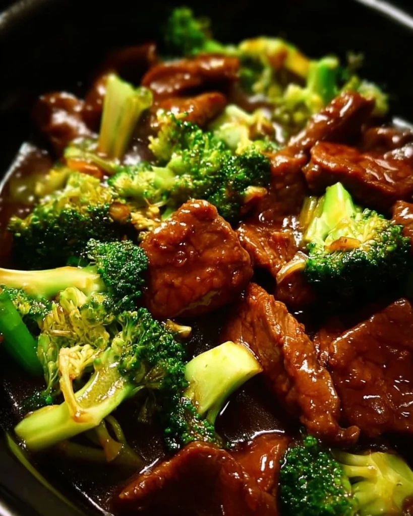 Crock pot beef and broccoli dish served on a plate with steamed rice